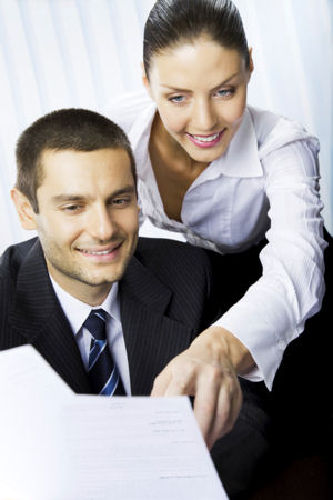 business woman standing behind business man and pointing